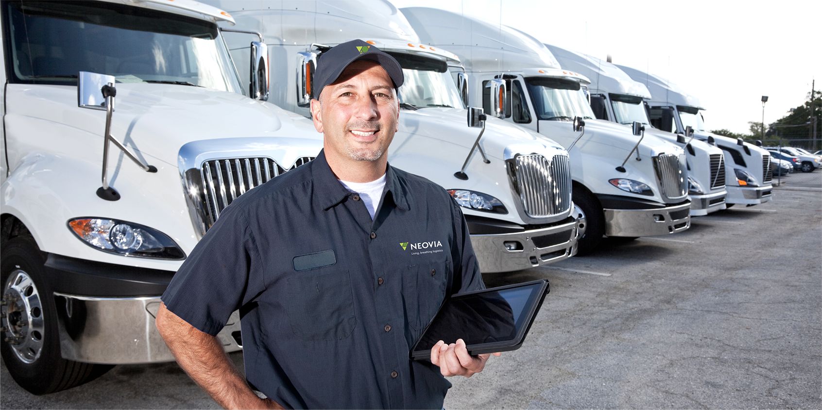 Neovia worker standing in front of row of semi trucks